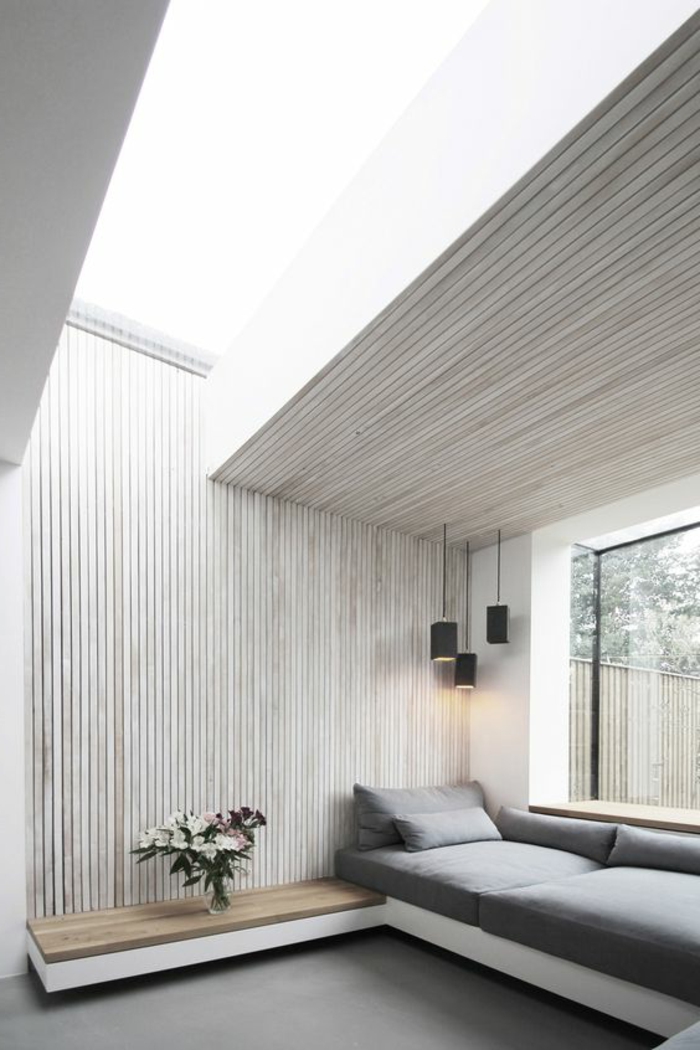 casa-minimalista-pared-de-madera-sofá-gris-grande-ventana-jarron-con-flores