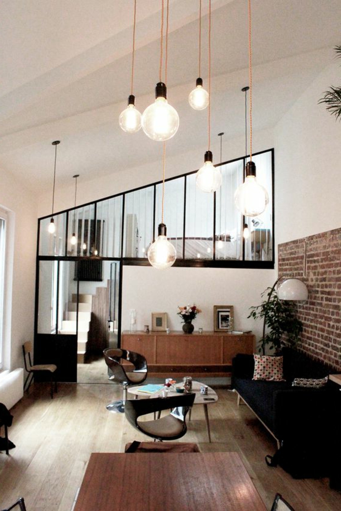 casas-minimalistas-sofa-en-negro-pared-con-ladrillos-lámparas-colgantes
