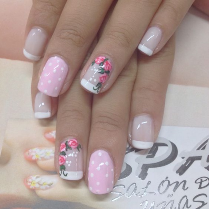 diseño de uñas romántico, color rosa, con puntos blancos, dibujo de rosas en el dedo anular