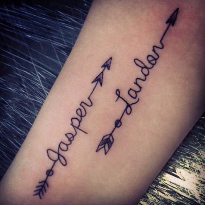 letras tatuajes, dos flechas en la mano con nombres importantes, tatuaje bonito