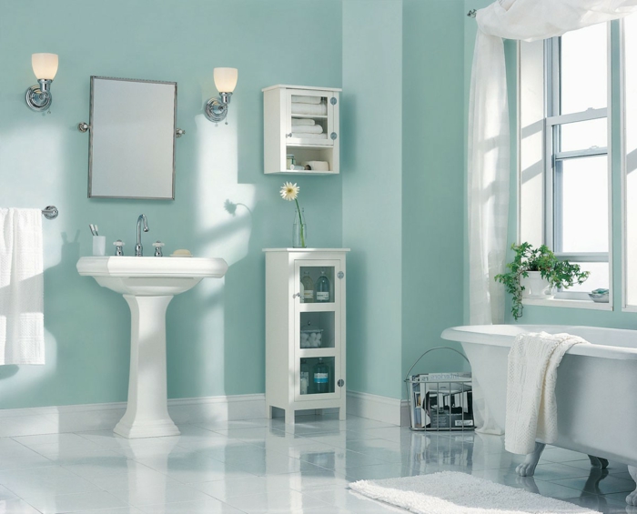 colores pastel, cuarto de baño en azul pastel, decorado con flores, espejo entre lámparas, lavabo y bañera blancos