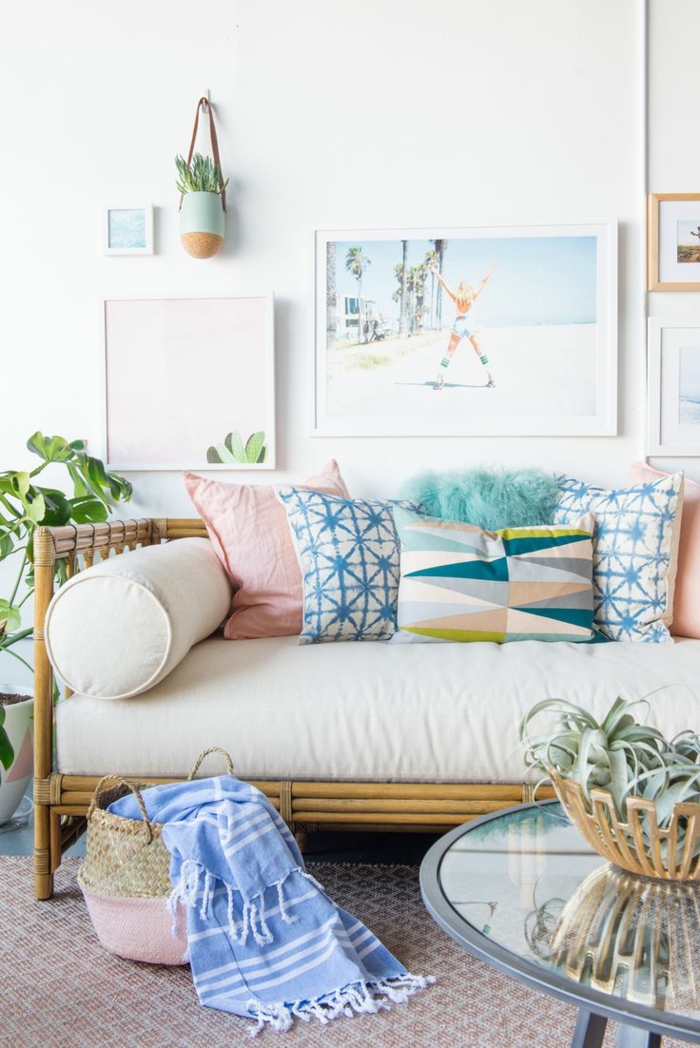 colores pastel, sofá con cojines de color, bolsa de rattan, mesa redonda de vidrio con planta