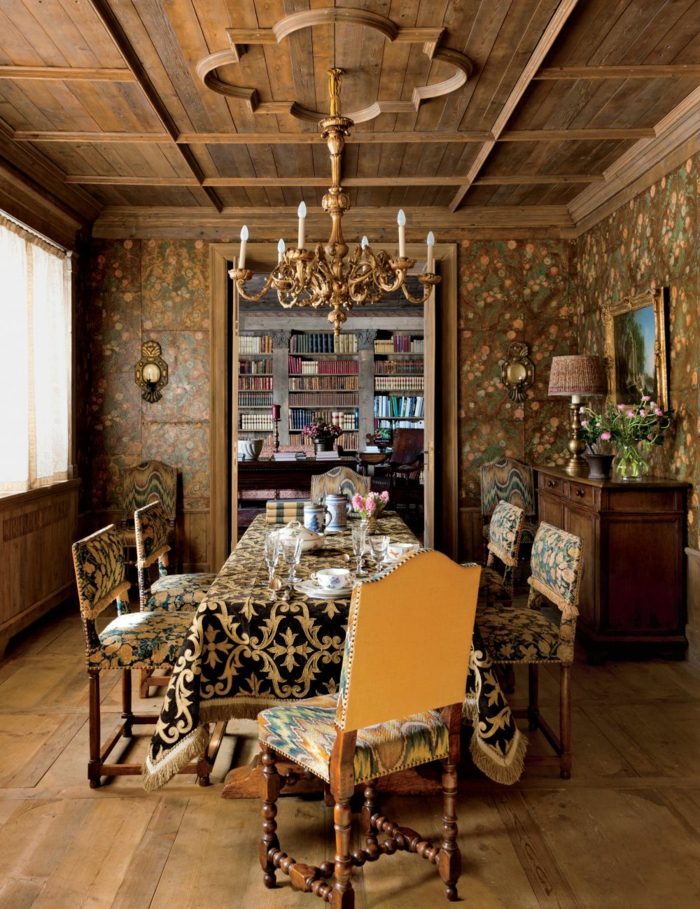 decoracion de comedores, comedor con mesa rectangular, mantel en negro y oro, sillas tapizadas, lámpara de araña, parqué, librería