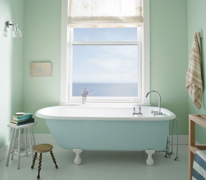 pintar paredes, baño decorado en verde y azul pastel, bañera con ventana, silla con libros