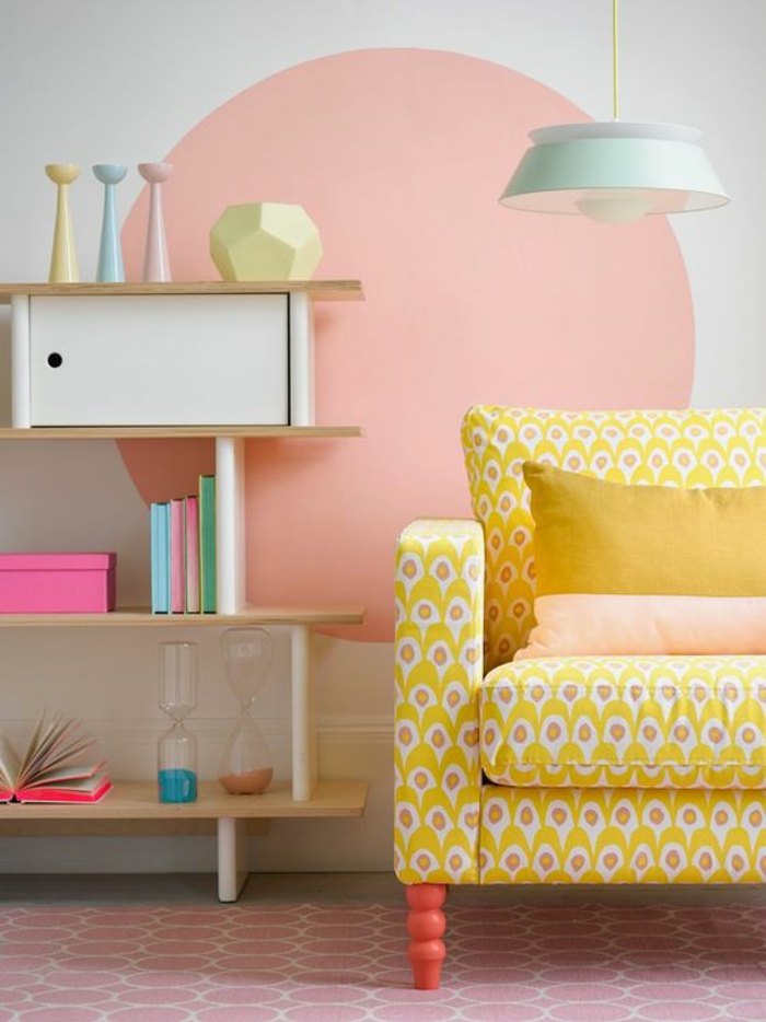 decoracion de paredes, decoracion con círculo de color rosa sobre pared blanca, sillón, estantería