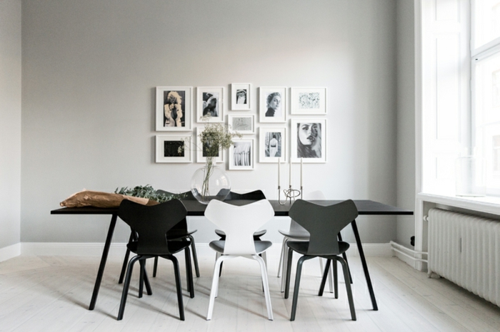 decoracion salon, comedor minimalista en blanco y negro, mesa rectangular, sillas irregulares, fotos en la pared