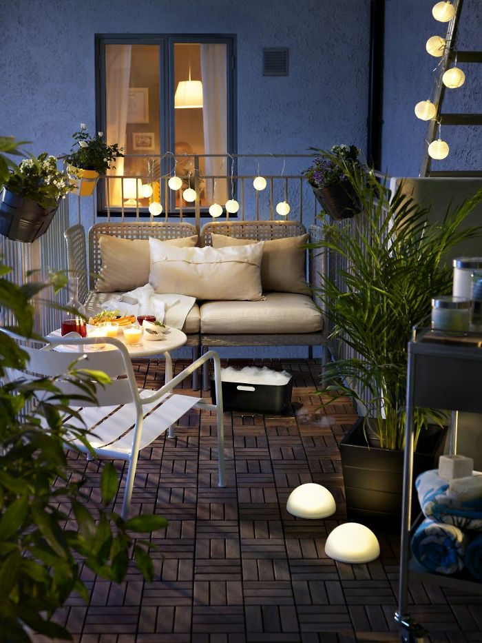 terrazas pequeñas, balcón con suelo de tarima, silla y sofá de metal con cojines, lámparas globos