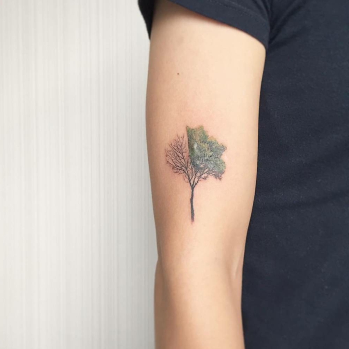 tatuajes en el antebrazo,tatuaje de arbol medio verde medio seco en brazo de mujer