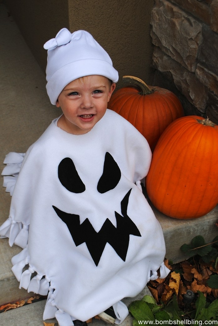 disfraces halloween caseros, niño con disfraz de espiritu blanco y calabazas
