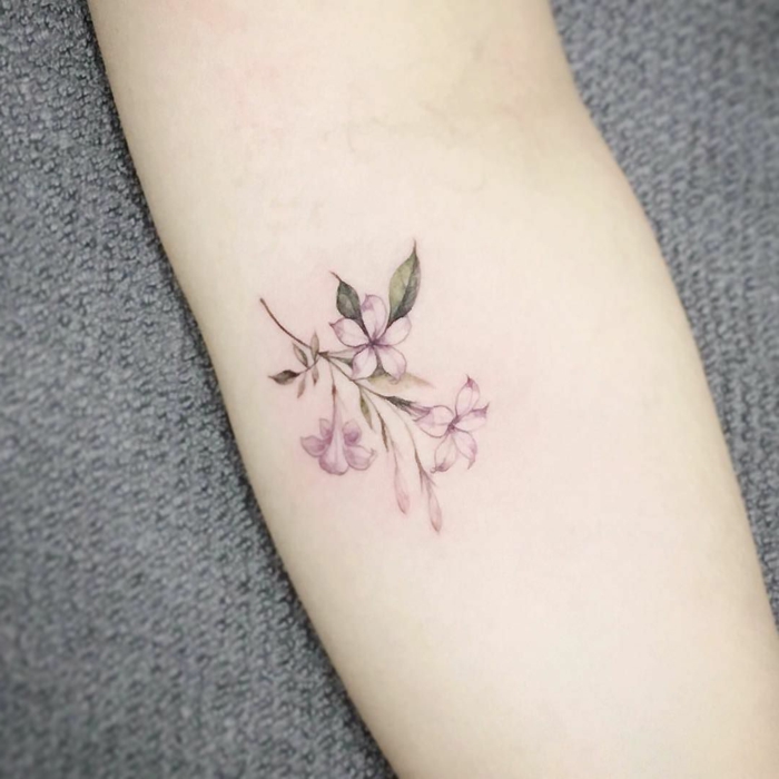 tatuajes en el brazo, mujer con tatuaje en el antebrazo, flor púrpura
