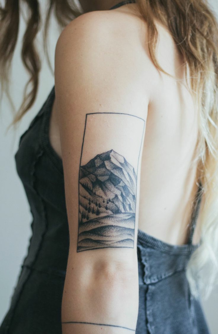 fotos de tatuajes, mujer rubia con tatuaje enmarcado de montaña