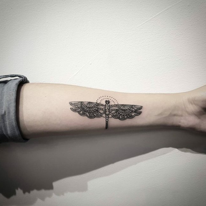tatuajes con significado. tatuaje con círculo y libélula en antebrazo