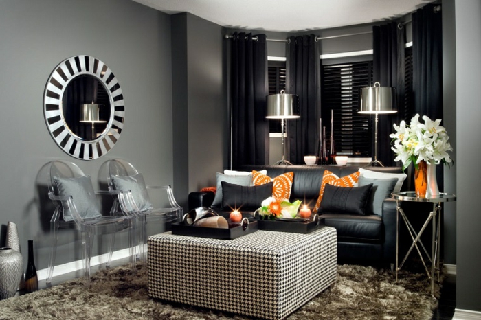 salones con encanto, salón poqueño en gris y negro con sillas de plástico transparente, cortinas y sofá en negro, cojines naranja