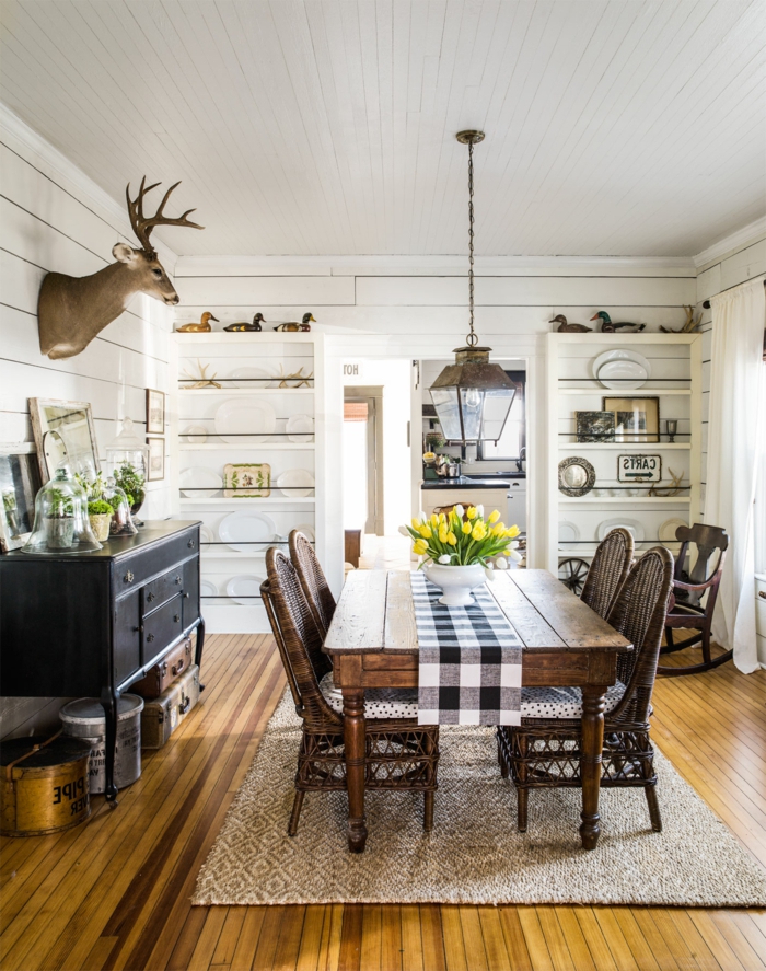 muebles salon, comedor con mesa de madera, alacena blanca, parqué y alfombra, cabeza de ciervo