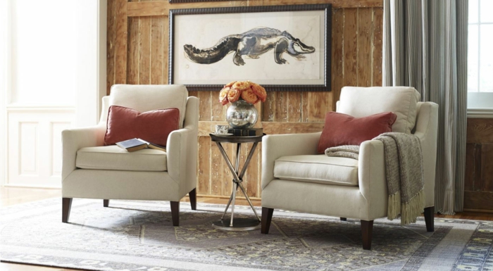 decoracion de interiores salones, salón con dos sillones iguales, cojines rojas, pared de madera y cuadro con cocodrilo