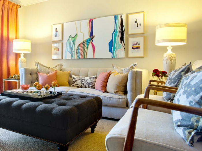salones modernos, salón con cuadro abstracto, sofá beige con cojines, sillones y taburete de mesa, lámparas simétricas