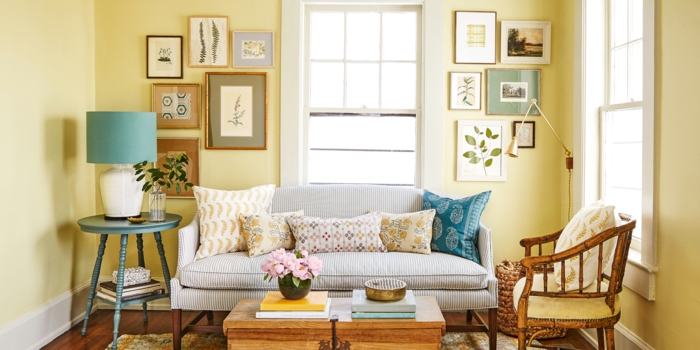 decoracion de salones, salón pequeño con paredes amarillas, plantas enmarcadas, sofá rayada con cojines, mesa y sillón de madera