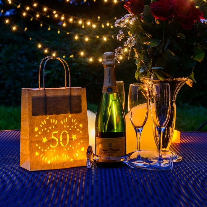 decoracion cumpleaños, notella de champaña con vasos, bolsa de regalo con edad iluminada