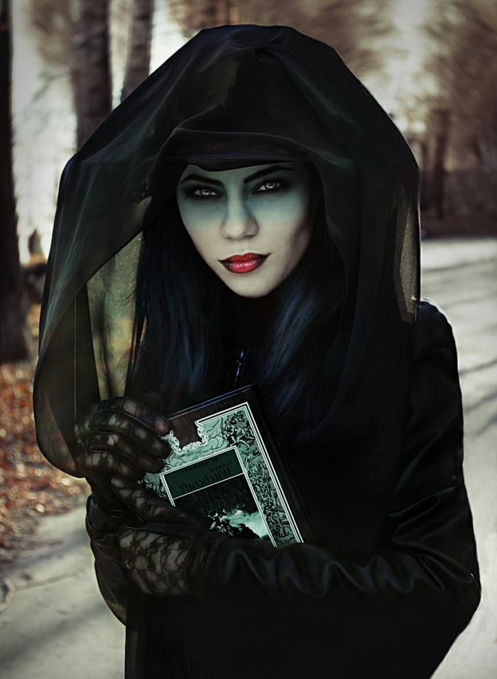 ideas para halloween, bruja malvada en negro, mirada profunda con lentes de contacto, labios en rojo y negro