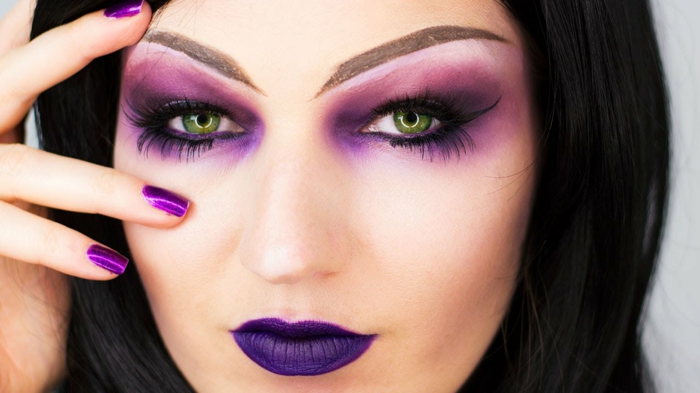 maquillaje halloween mujer, cara ahumada en tonos morados, labial y uñas en lila, cejas alargadas con lápiz 