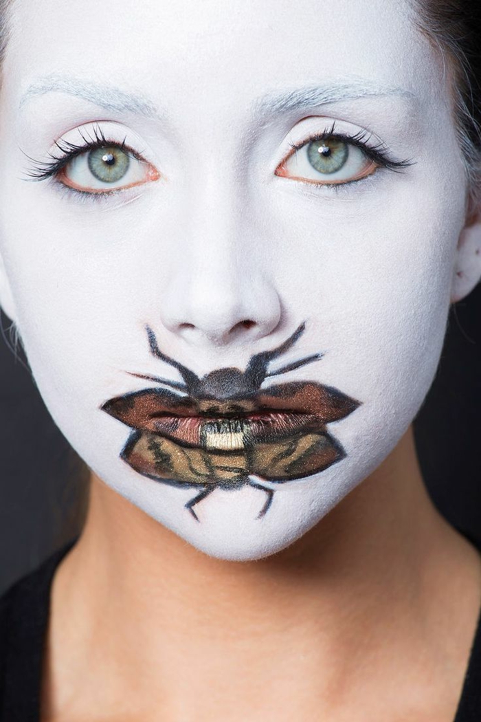 maquillaje halloween, mujer maquillada con cara en blanco y mosca pintada sobre los labios