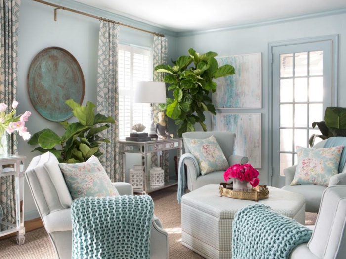 salones modernos, salón clásico con paredes en azul, sillones alrededor de mesa, cojines y grandes plantas verdes