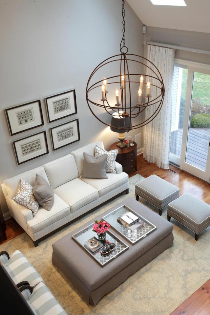 decoracion salones pequeños, salón en blanco y gris con lámpara araña, ventanales y tapete, taburetes y sillones