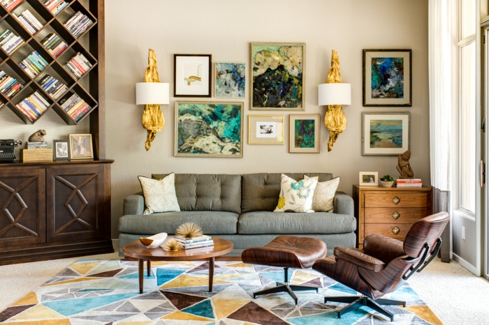 decoracion salones modernos, salón con sillón de piel, sofá con cojines. mesa redonda, estantería de madera iregular
