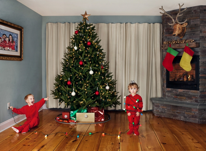 arboles de navidad decorados, pino grande vivo decorado con esferas en blanco y rojo y lamparillas en amarillo, chimenea acogedora 