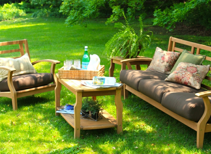 diseño de jardines, zona para descanso, muebles de madera clara, sofá con almohadas decorativas, grande patio verde
