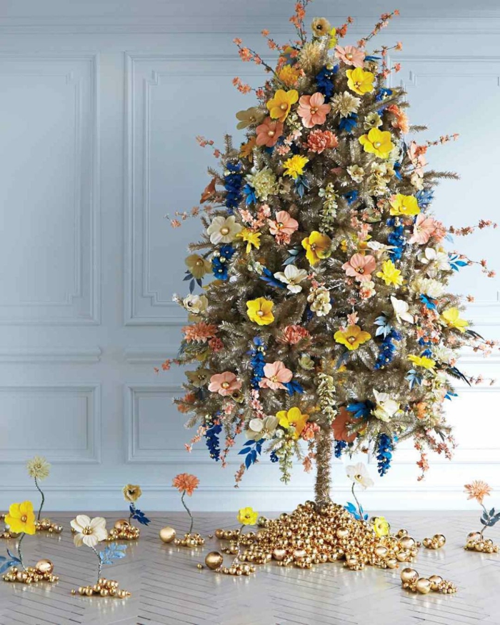 árbol de navidad artificial, de pequeño tamaño, decorado con ornamentos de flores en diferentes colores y pequeñas bolas doradas