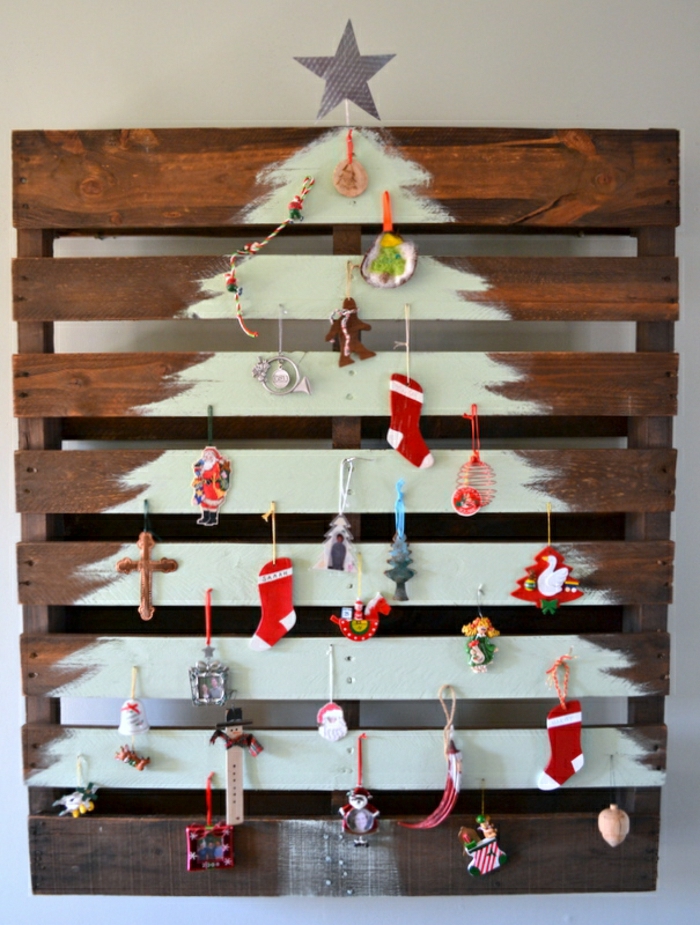 como hacer un arbol de navidad dibujándolo en madera, pequeños ornamentos de encanto colgados en clavos