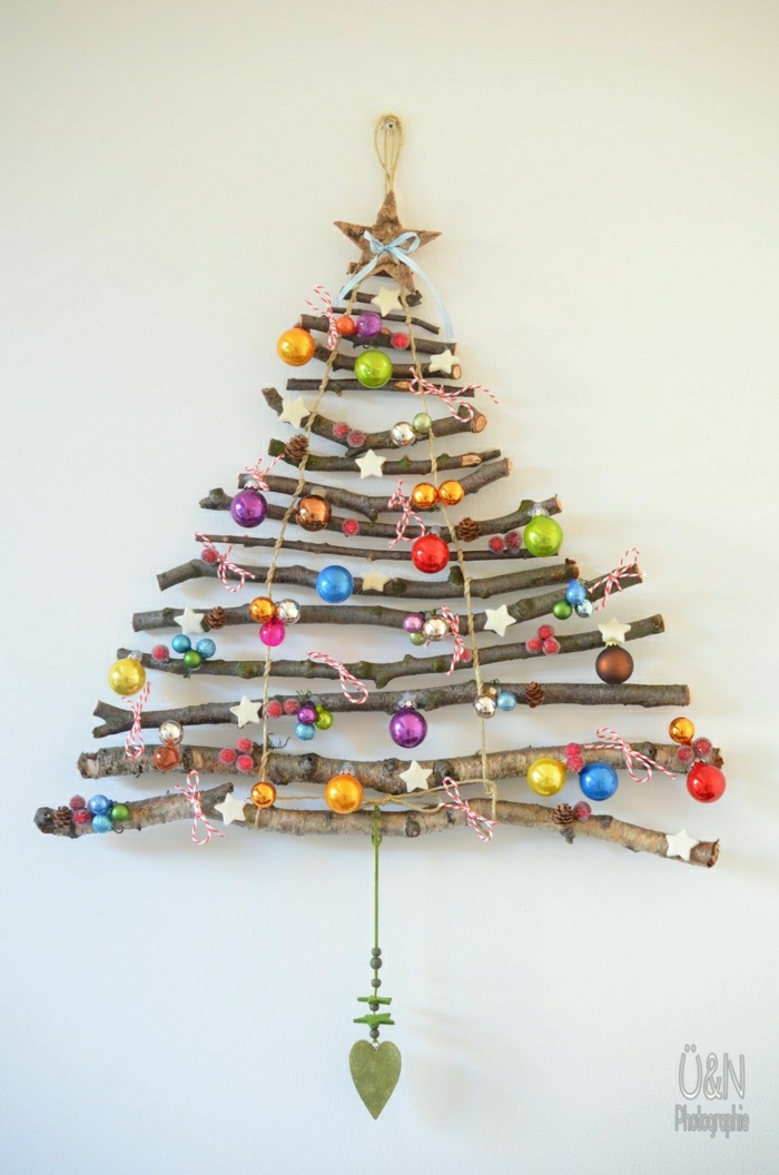 como decorar un árbol de navidad, árbol casero hecho de palos de madera, colgado en la pares, con pequeñas bolas en diferentes colores