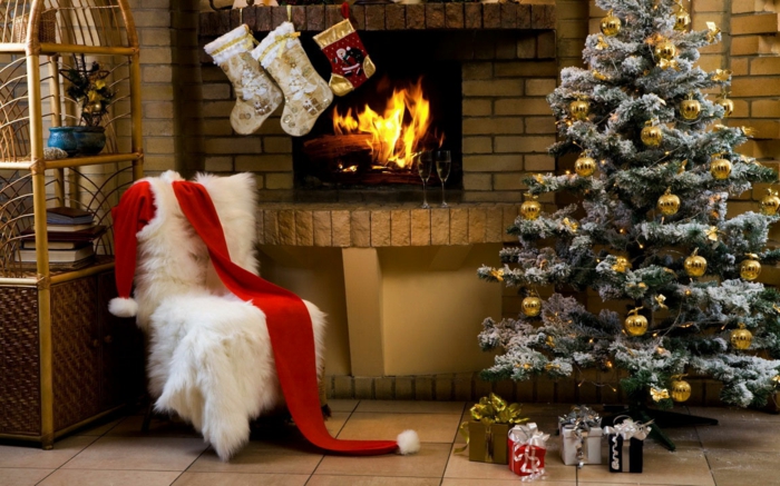 decorar arbol de navidad, pino artificial con efecto nevado, bolas doradas como decoración, calcetines navideños colgados en la chimenea