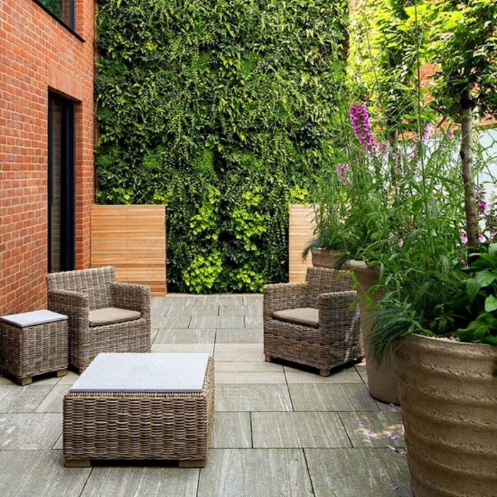 jardines modernos, muebles simples de mimbre, macetas masivas con plantas salvajes, plantas trepadoras en la pared entera