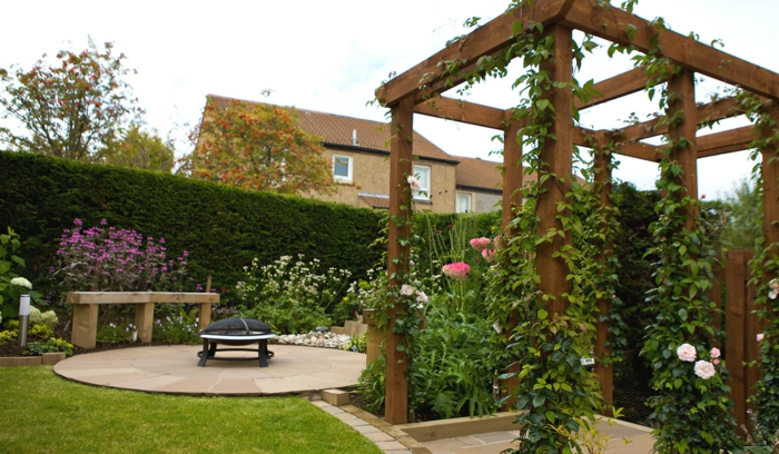 casa y jardin, bonito ejemplo de un patio de recreo moderno, pérgola de madera con plantas trepadoras, cesped muy bien mantenido