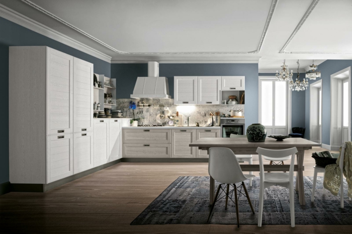 cocinas modernas, cocina grande con comedor, alacenas de madera blanca, mesa con sillas desparejas, paredes azules