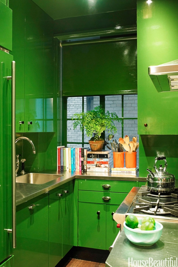 diseñar cocinas, ambiente en color atrevido, estantes hasta el techo pintados en verde, esquina para libros