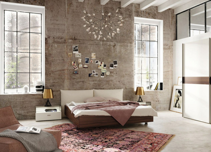 decorar habitacion, dormitorio matrimonio industrial, dos ventanas grandes, tapete rosado, lámpara de araña, cama doble y sillon