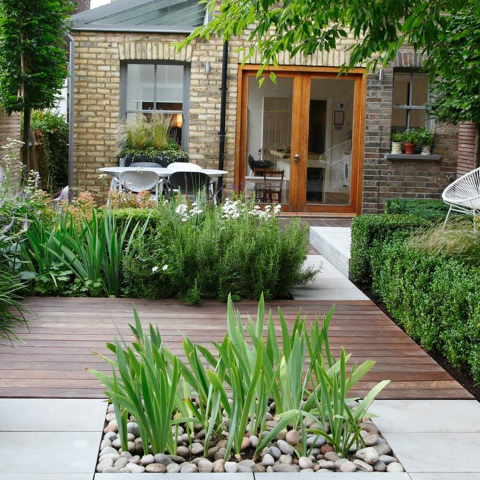 decoracion de jardines, bonito patio pequeño con parquet y parceles con plantas y piedras decorativas, casa estilo rústico