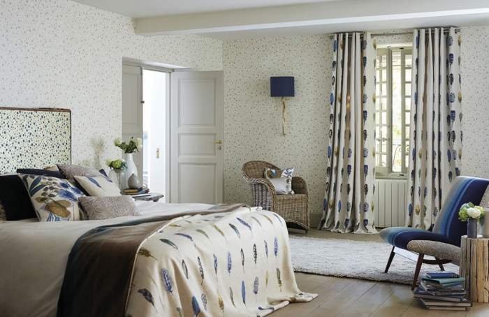 dormitorios matrimonio modernos, dormitorio con papel pintado en puntos, cortinas con plumas en blanco y azul, cama doble, silla de mimbre