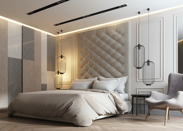 dormitorios matrimonio modernos, dormitorio beige, cama con canecero tapizado, lámparas negras colgantes y sillón