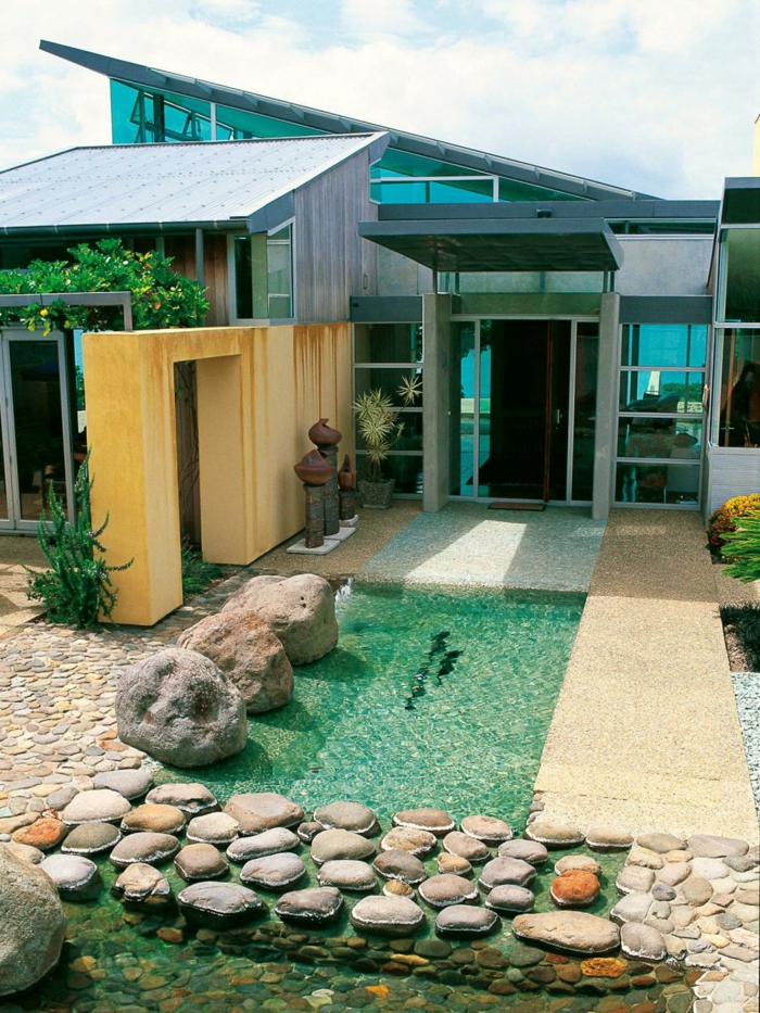 casas con piscina, casa moderna con paredes de vidrio, piscina pequeña decorativa con piedras