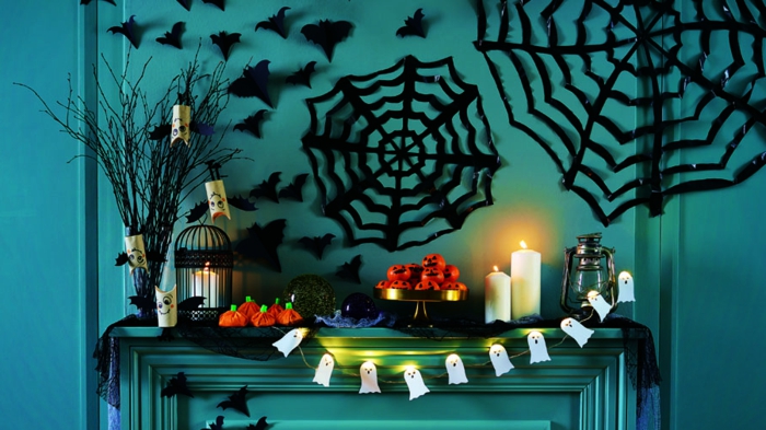 ideas para halloween, propuesta fácil para decorar las paredes, adornos en formas de telarañas grandes, pequeños murciélagos, guirnaldas de fantasmas pequeños, velas decorativas