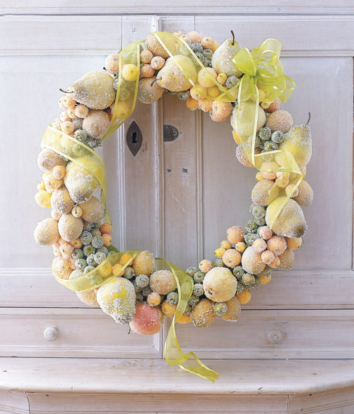 guirnaldas de navidad, corona amarilla de navidad con frutas, peras, bayas y manzanas cubiertas de escarcha con cinta decorativa