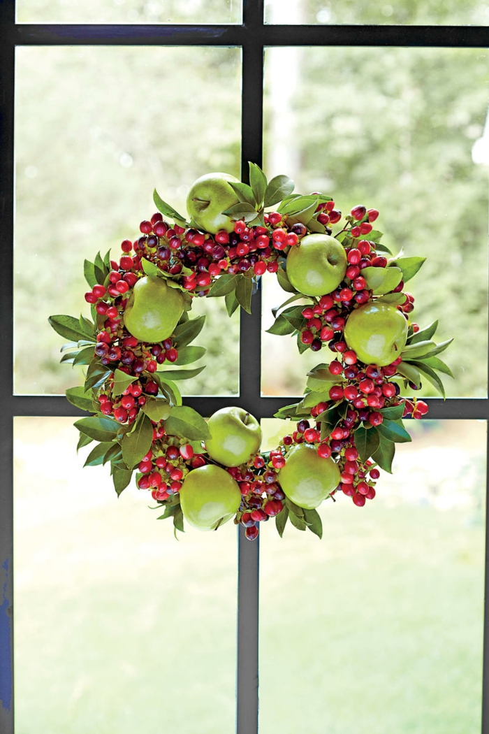guirnaldas de navidad, corona de navidad de hojas verdes, manzanas y muerdago rojo, ventana con marco negro