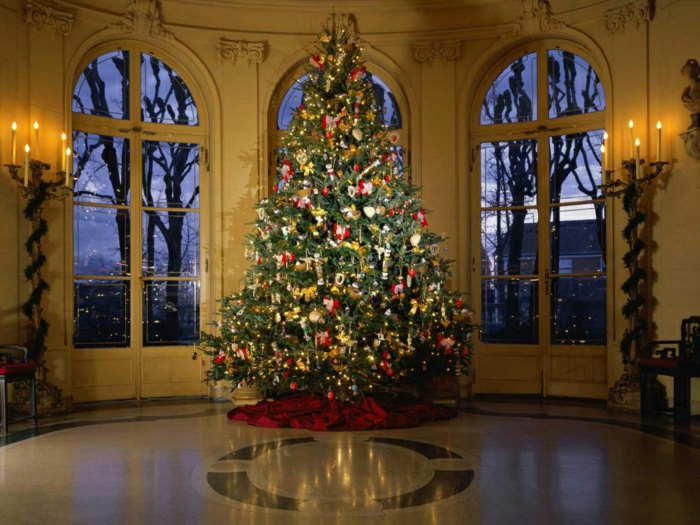 arboles de navidad originales, grande salón con ventanas de techo a suelo, árbol grande decorado con adornos rojos y color oro, 