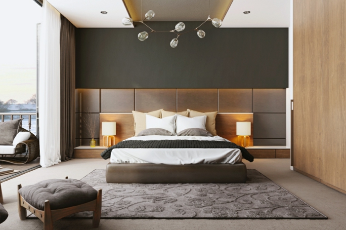 decoracion dormitorios, dormitorio con cabecero tapizado y cama doble, taburete y alfombra, ventanal hacia balcón