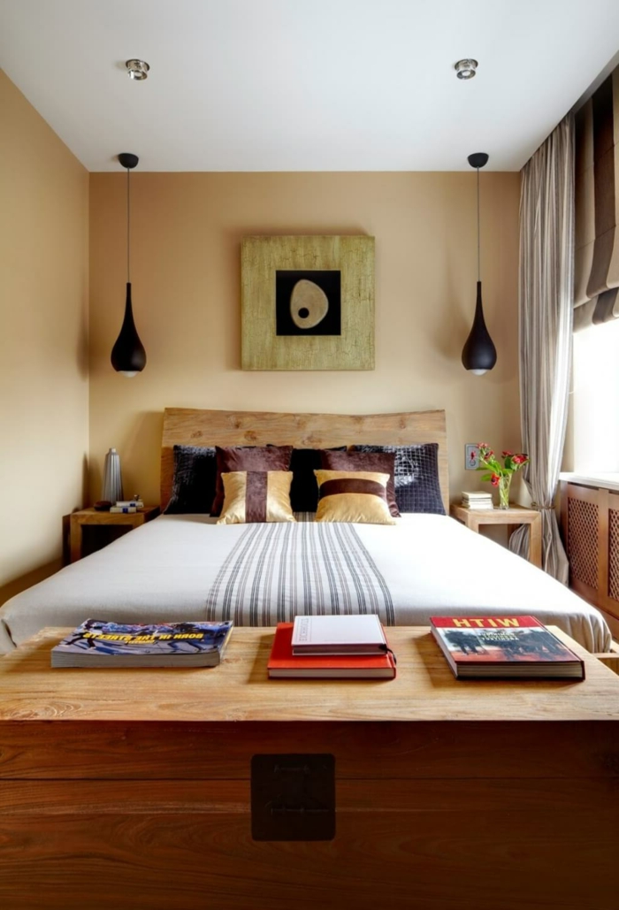 decoracion dormitorios, dormitorio pequeño, caja de madera con libros, cama doble con cabecero de madera, lámparas colgantes negras