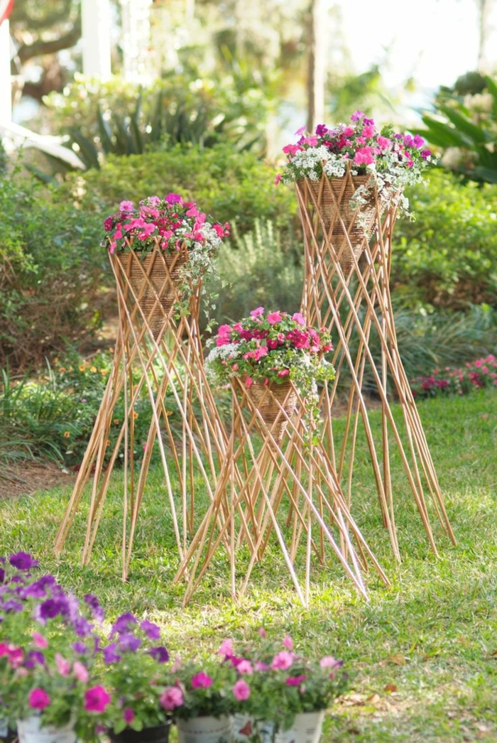 maceteros de madera, macetas tejidas elevadas en palos de madera, petunias rosa y blanco, jardín con césped